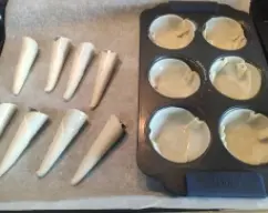 Step <p>Precalienta el horno a 180º, pincela los moldes de magdalenas y los conos con aceite o spray desmoldante. Coloca las obleas en los moldes de magdalenas ajustando los bordes, y enrolla las obleas alrededor de los conos para darle la forma y sella el borde con un poco de agua. Pinta las cestas y los conos formados con huevo batido y hornéalos unos 10 minutos a 180 º, dejad que enfríen y una vez fríos ya se podrían rellenar.</p> illustration