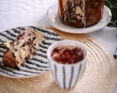 Step <p>Sacamos el pantettone del horno y rápidamente lo atravesamos por la mitad inferior con una brocheta y lo colocamos boca abajo hasta que se enfríe completamente. Espolvoreamos la superficie con azúcar glass.</p> illustration